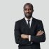 Handsome young African man in formalwear looking at camera while standing against grey background